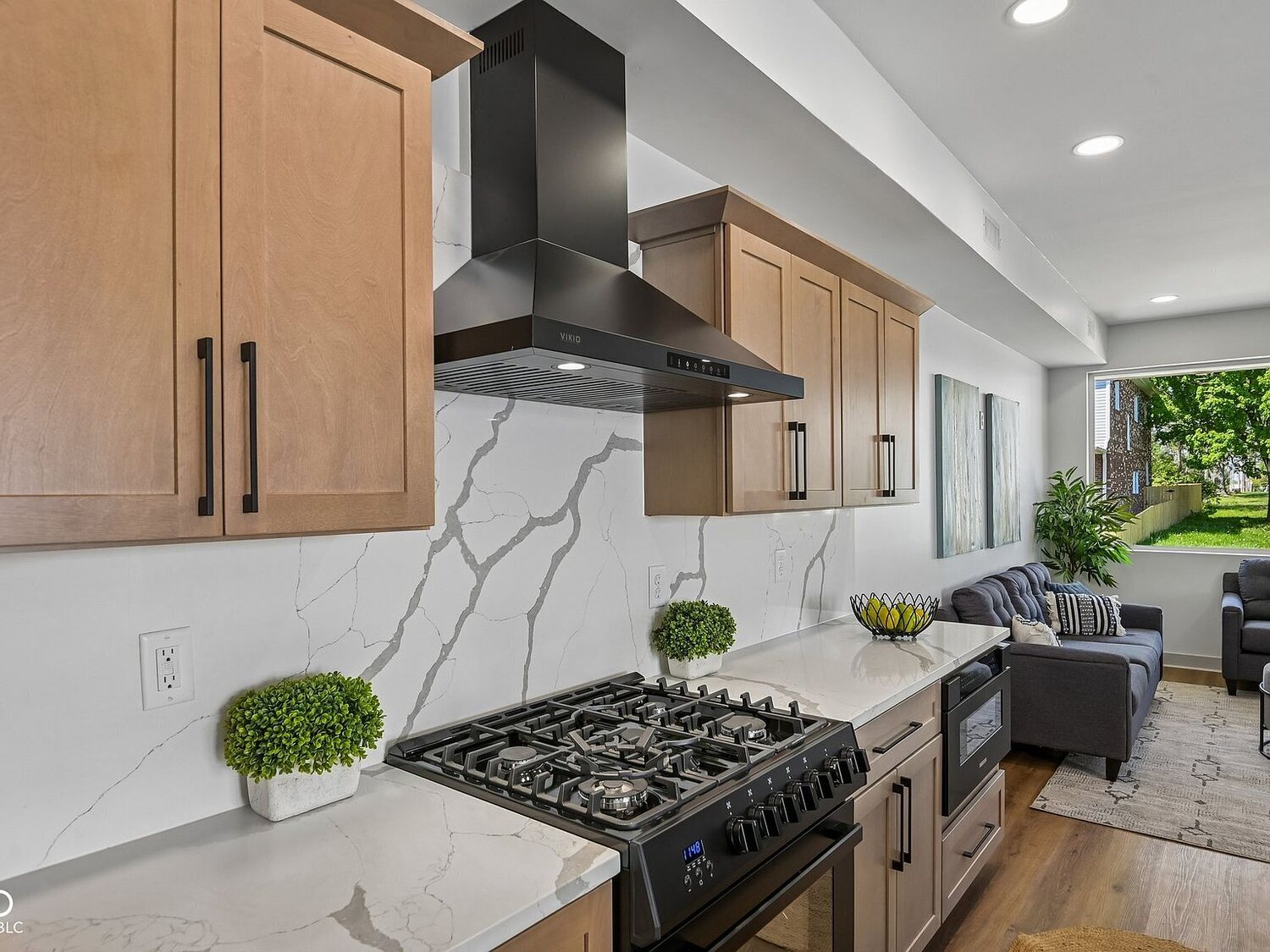 Quartz kitchen with gas range and custom hood